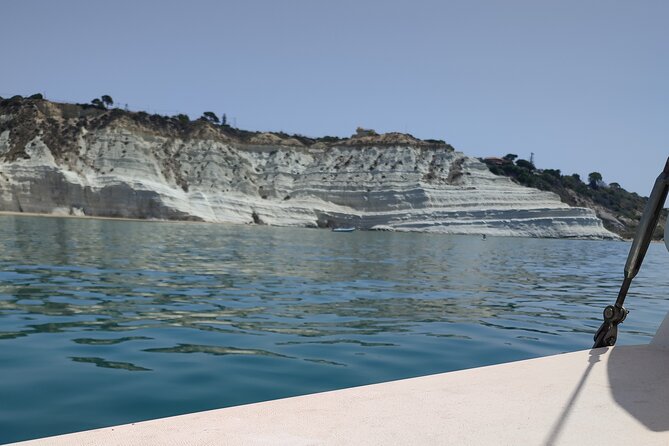4 Hours Catamaran Tour to the Scala dei Turchi - Le Pergole: clear water, paddle time, and a view toward Monterosso Tower
